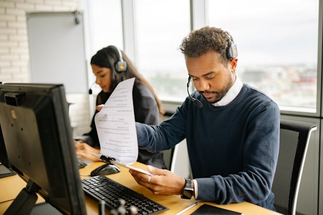 man with headphones looking at a document